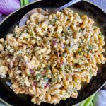 A colorful bowl of creamy pasta salad filled with fresh chopped vegetables.