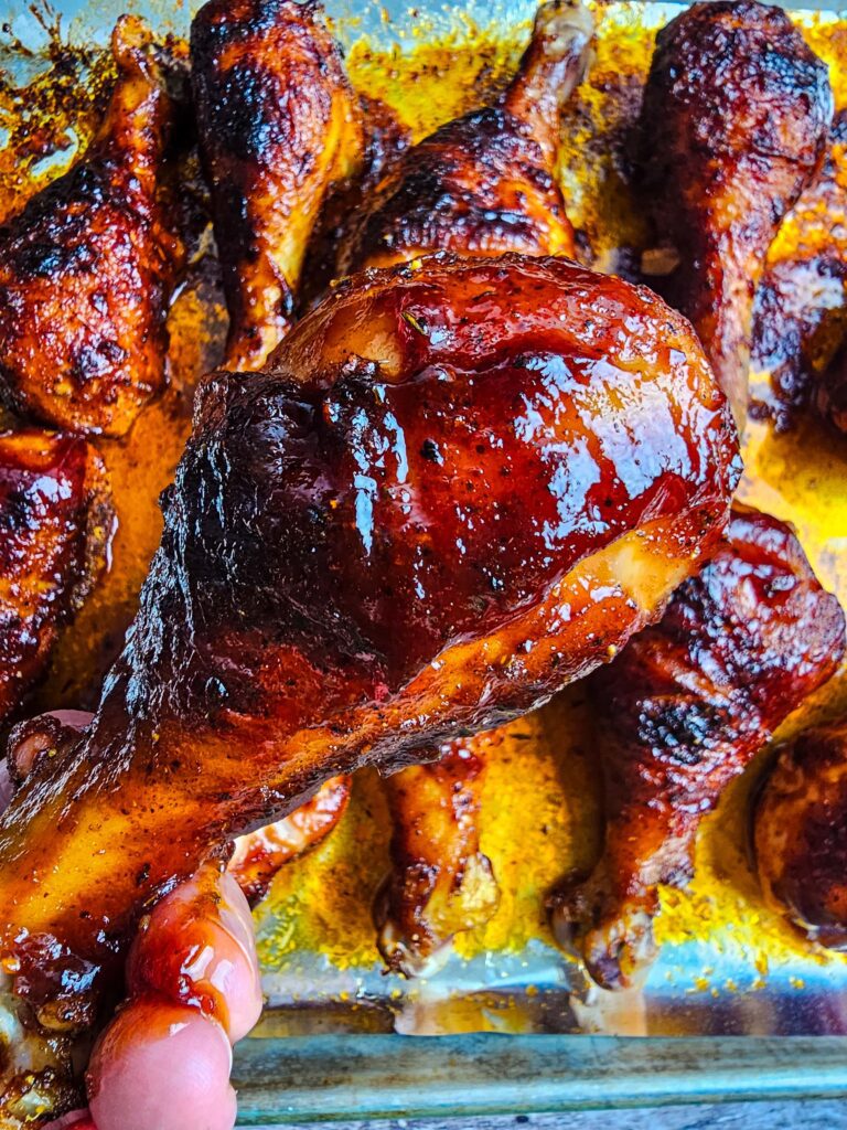 up close picture of a sticky bbq sauce covered chicken leg