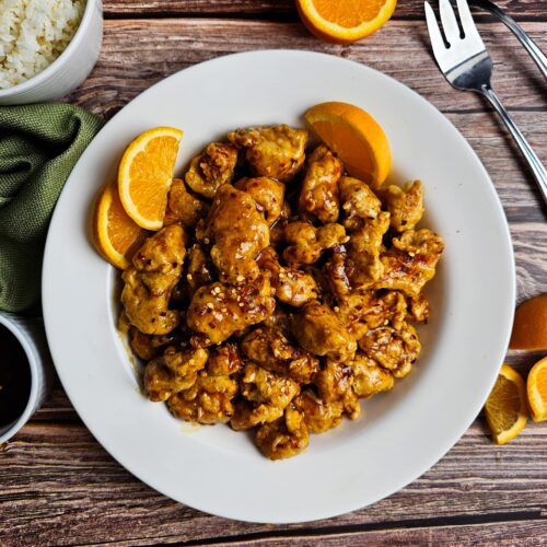 PLATER FULL OF ORANGE CHICKEN GARNISHED WITH ORANGE SLICES