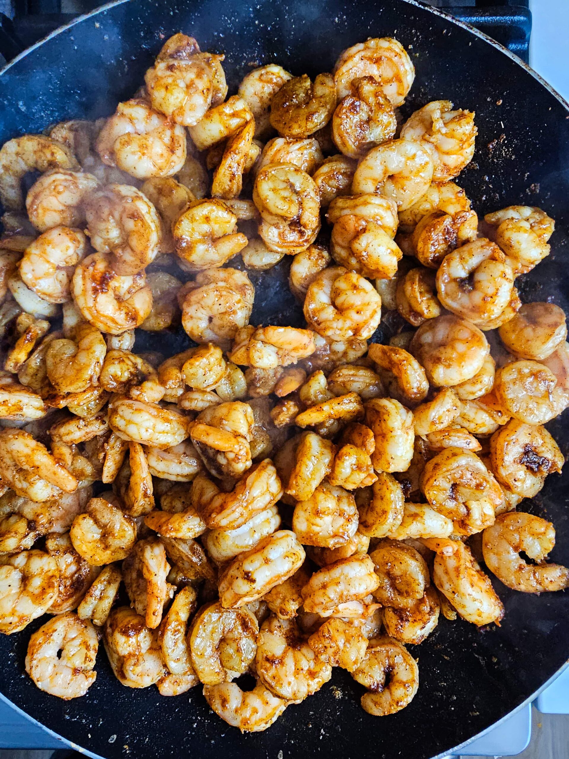SAUTE THE RAW SHRIMP IN A LARGE SKILLET AND SEASON WITH THE SPICE BLEND