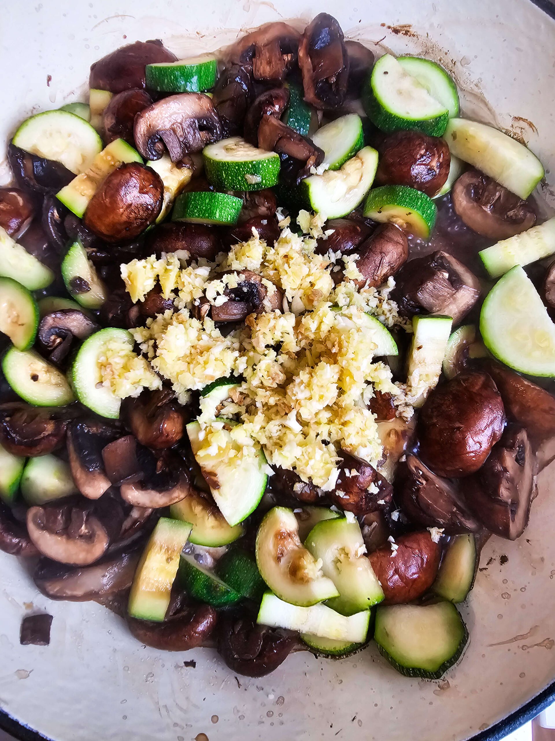 ADD THE GINGER AND THE GARLIC TO THE CAST ENAMAL SKILLET