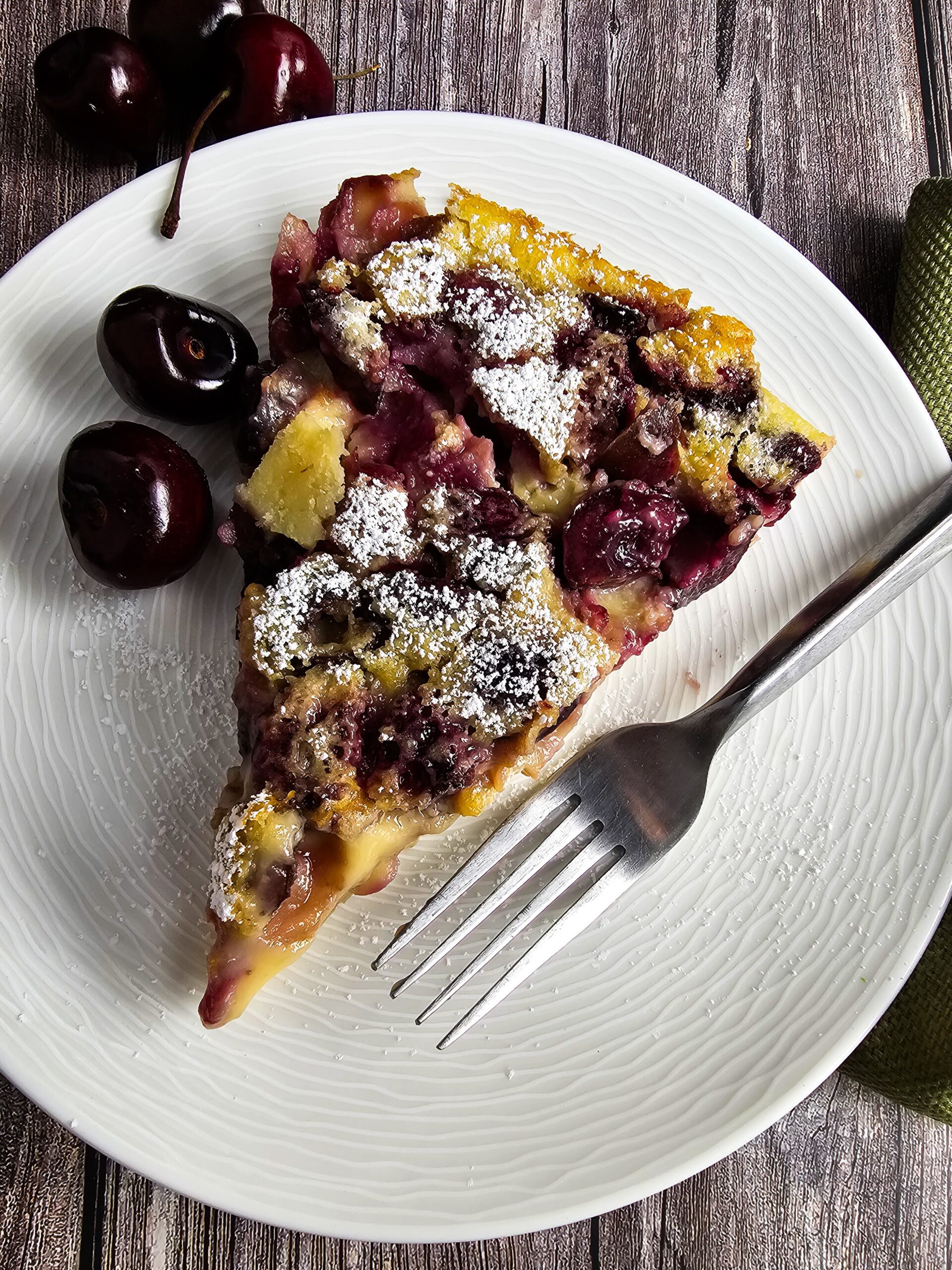 PLATED SLICE OF THE FRESH CHERRY DESSERT DUSTED WITH POWDERED SUGAR