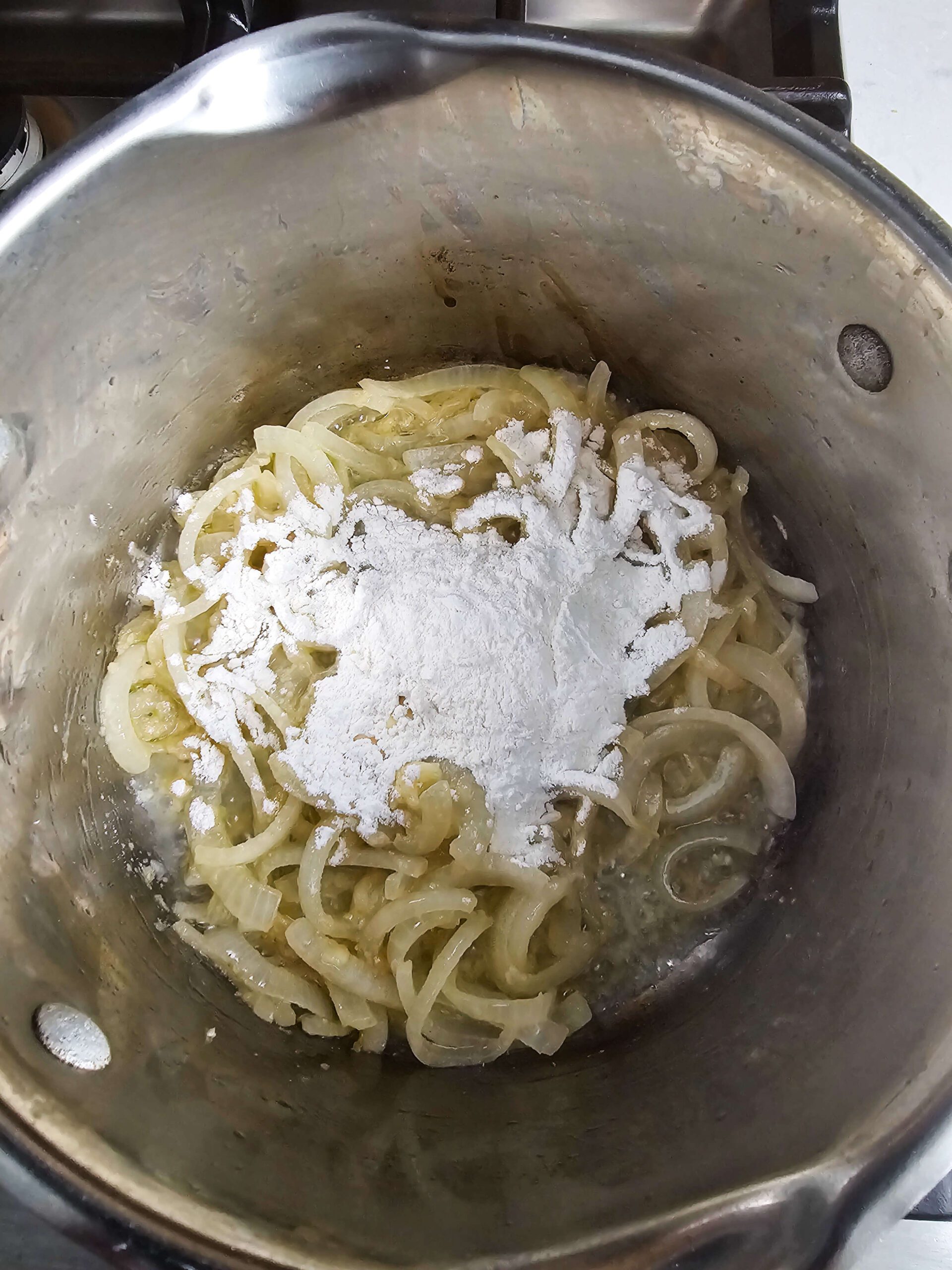 PHOTO OF SAUTEED ONIONS SPRINKLED WITH FLOUR TO MAKE A ROUX
