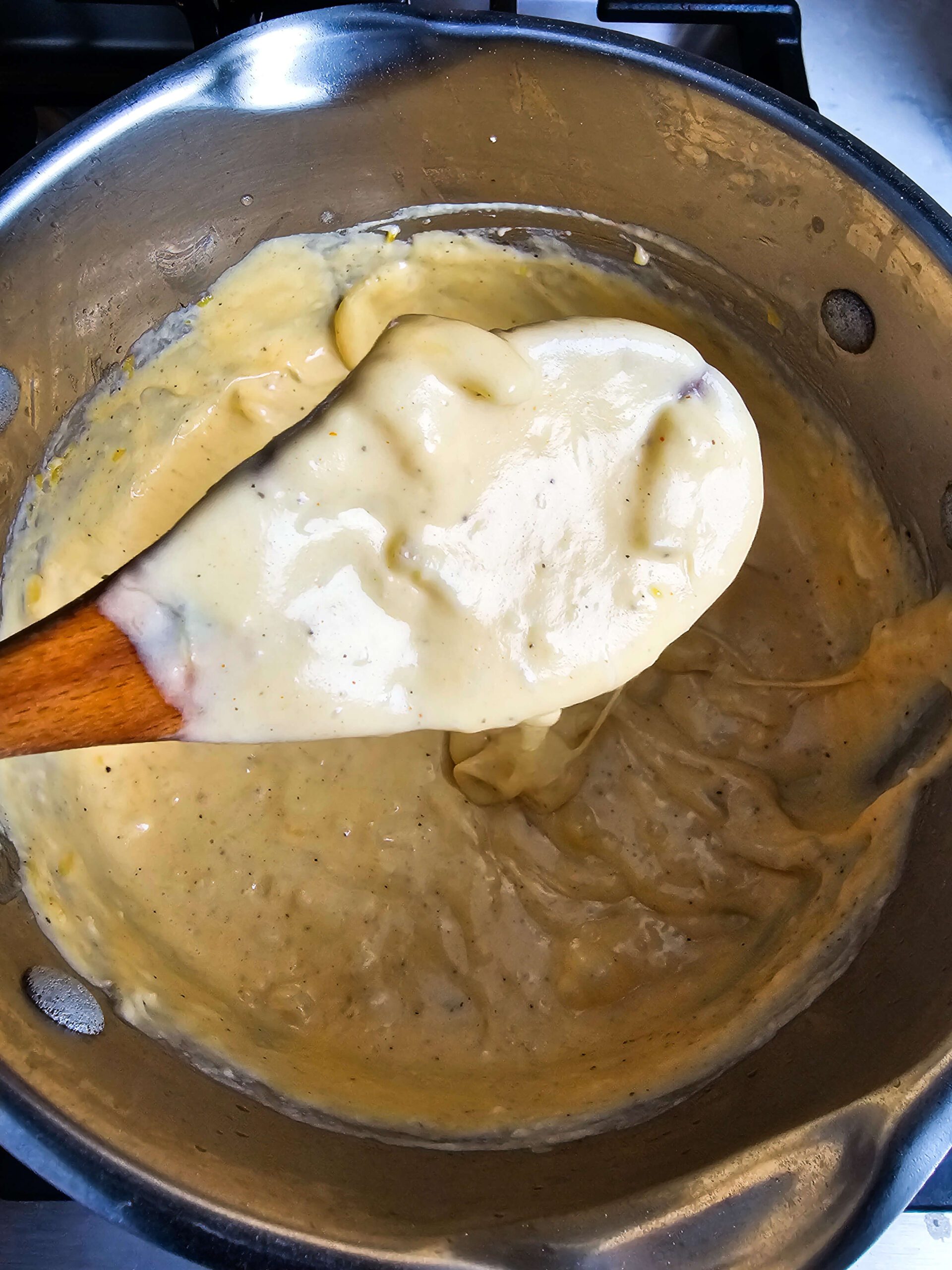 ADDING MILK AND CHEDDAR TO CREATE THE CREAMY SAUCE