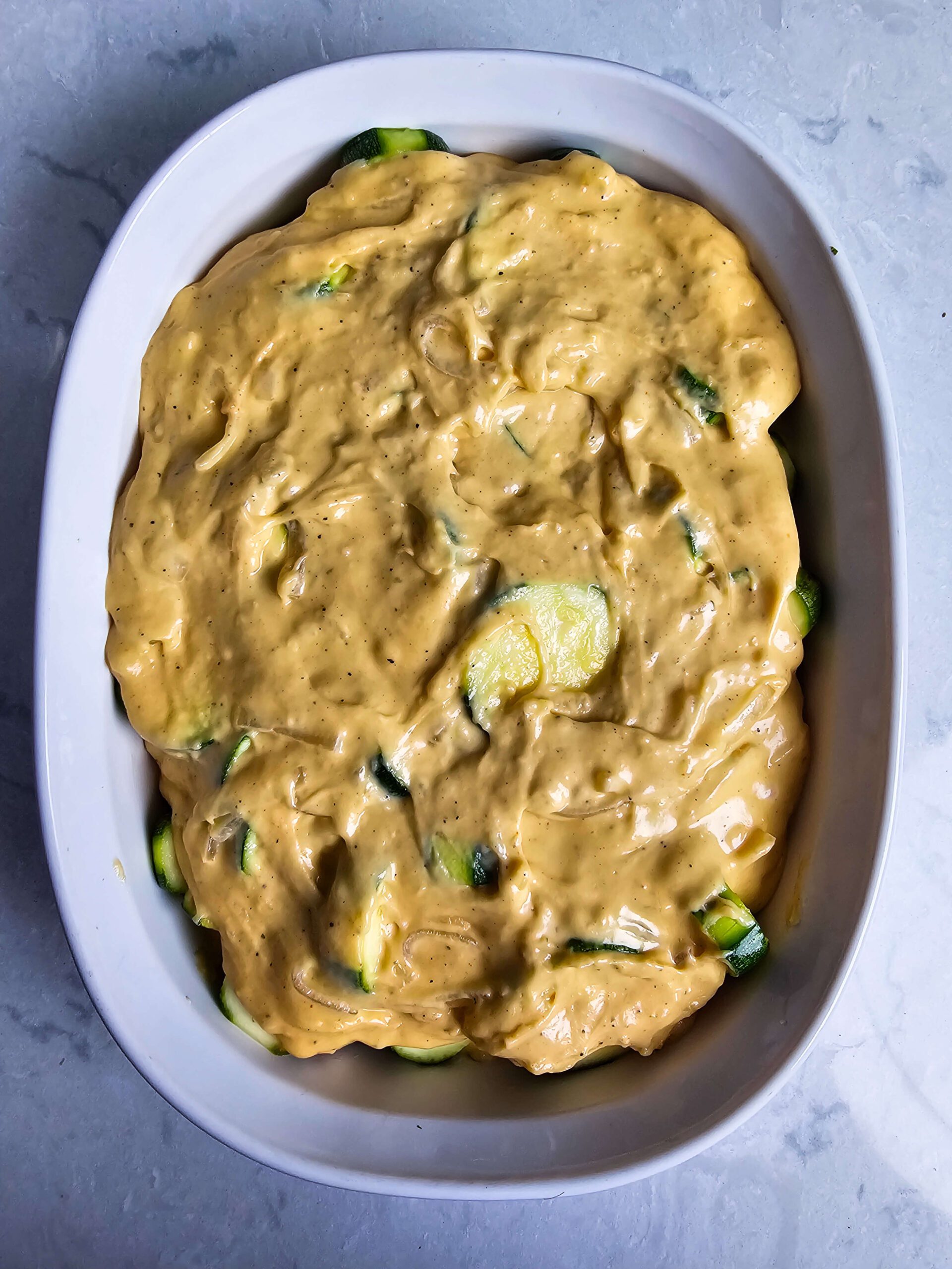 PHOTO IS LAYERING AND ASSEMBLING THE CASSEROLE.