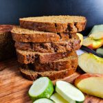 SLICED ZUCCHINI APPLE MOLASSES BREAD STACKED UP FIVE HIGH GARNISHED WITH SLICED ZUCCHINI AND APPLES