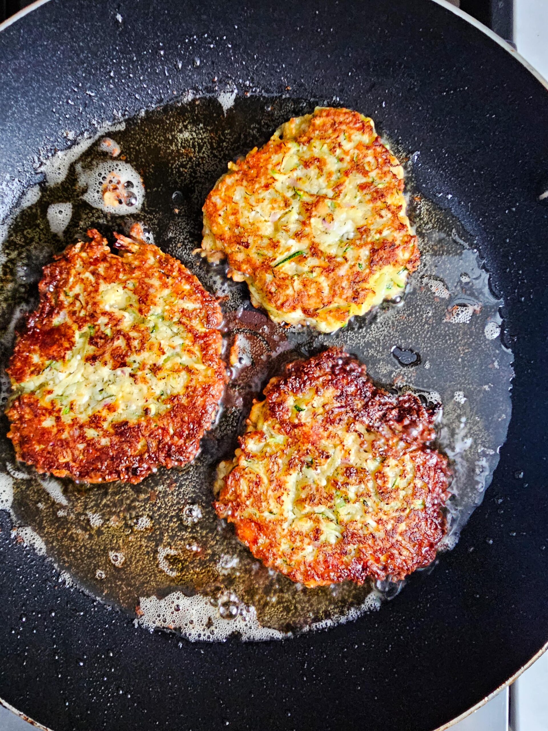 FLATTEN THE FRITTERS IN THE OIL EVENLY AND FRY UNTIL CRISP
