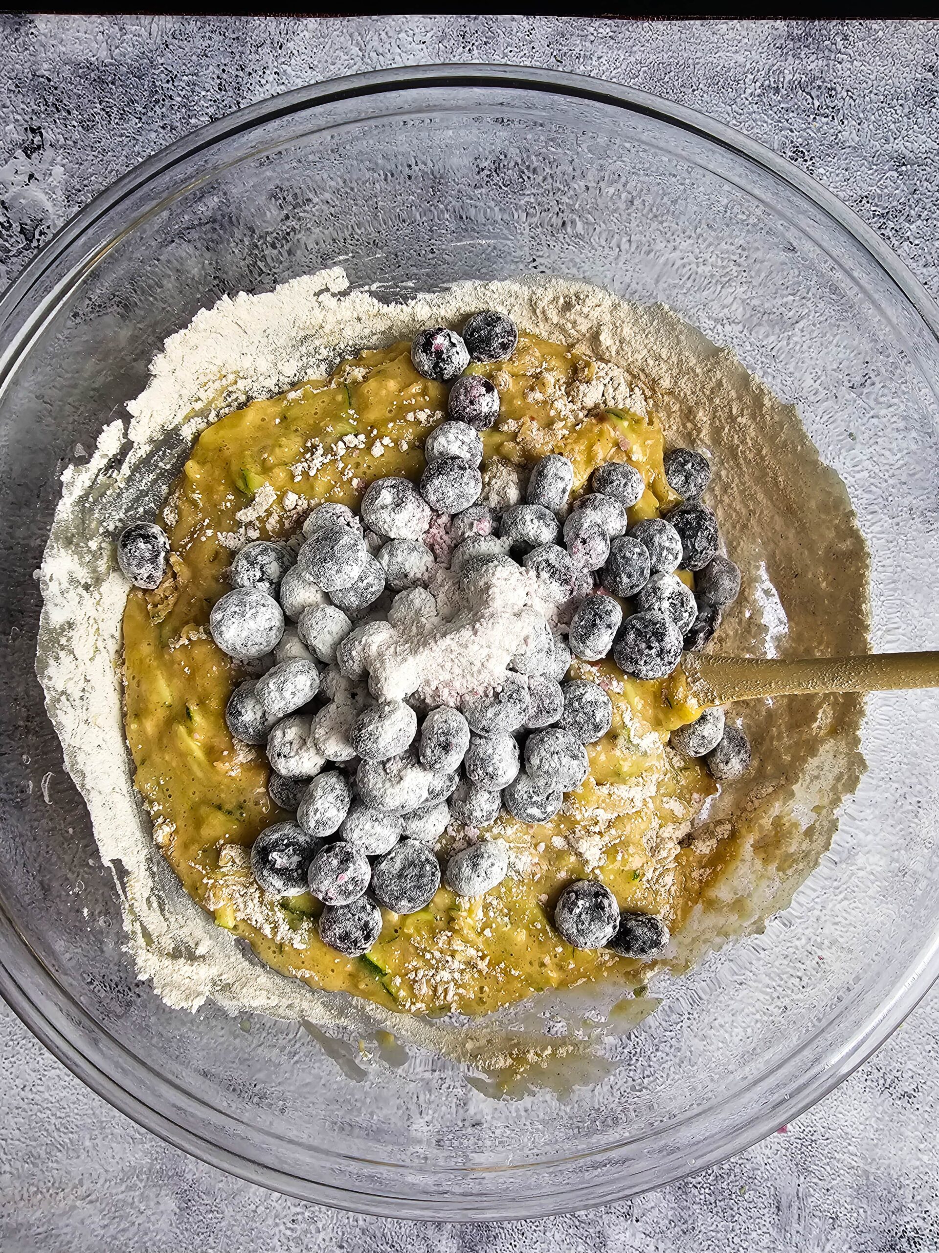 ADD THE FLOUR COATED BLUEBERRIES TO THE BATTER AND FOLD IN GENTLY