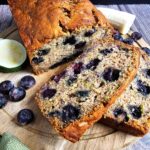 SLICED MOIST ZUCCHINI BANANA BLUEBERRY BREAD ON A WOODEN CUTTING BOARD