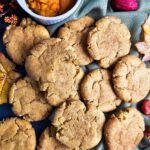 PILE OF SCATTERED COOKIES WITH A SMALL BOWL OF FRESH PUMPKIN PUREE