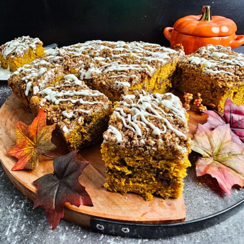 PUMPKIN COFFEE CAKE SLICED ON A WOODEN CUTTING BOARD