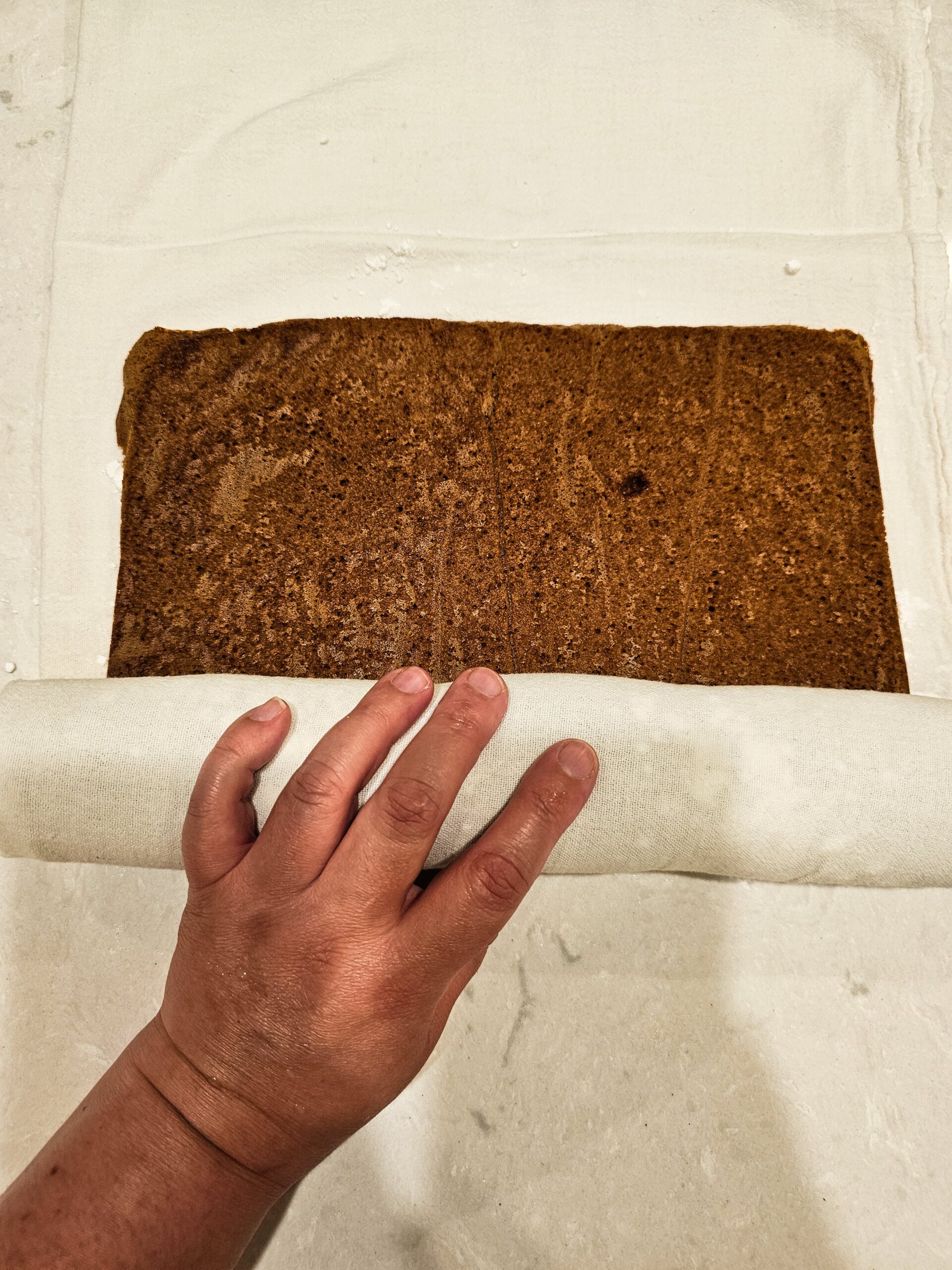 ROLL IN THE WARM CAKE ON A POWDERED SUGAR DUSTED CLEAN DISH TOWEL.