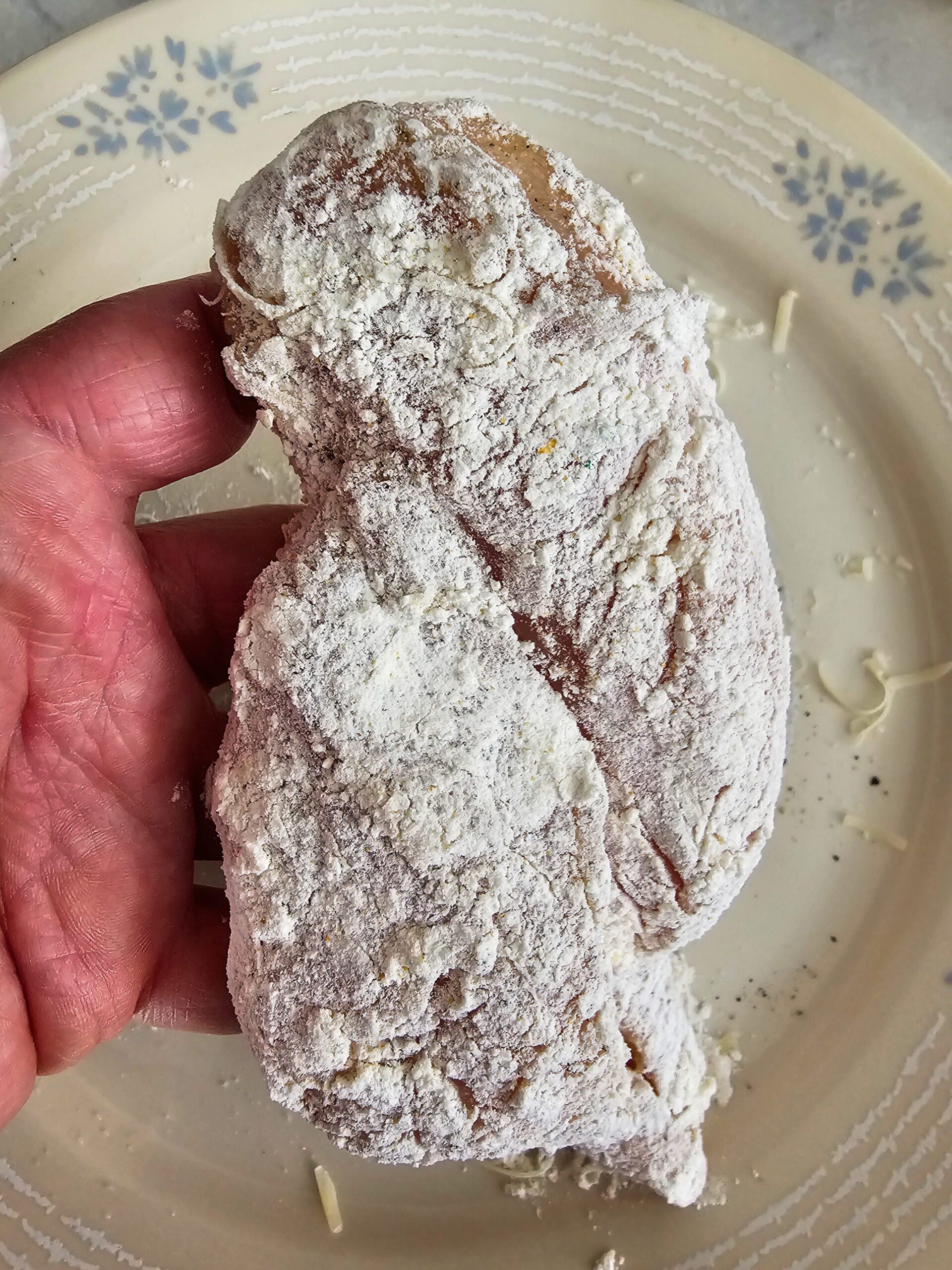 Chicken breasts sliced into thin even cutlets seasoned with salt and pepper ready to dredge in flour