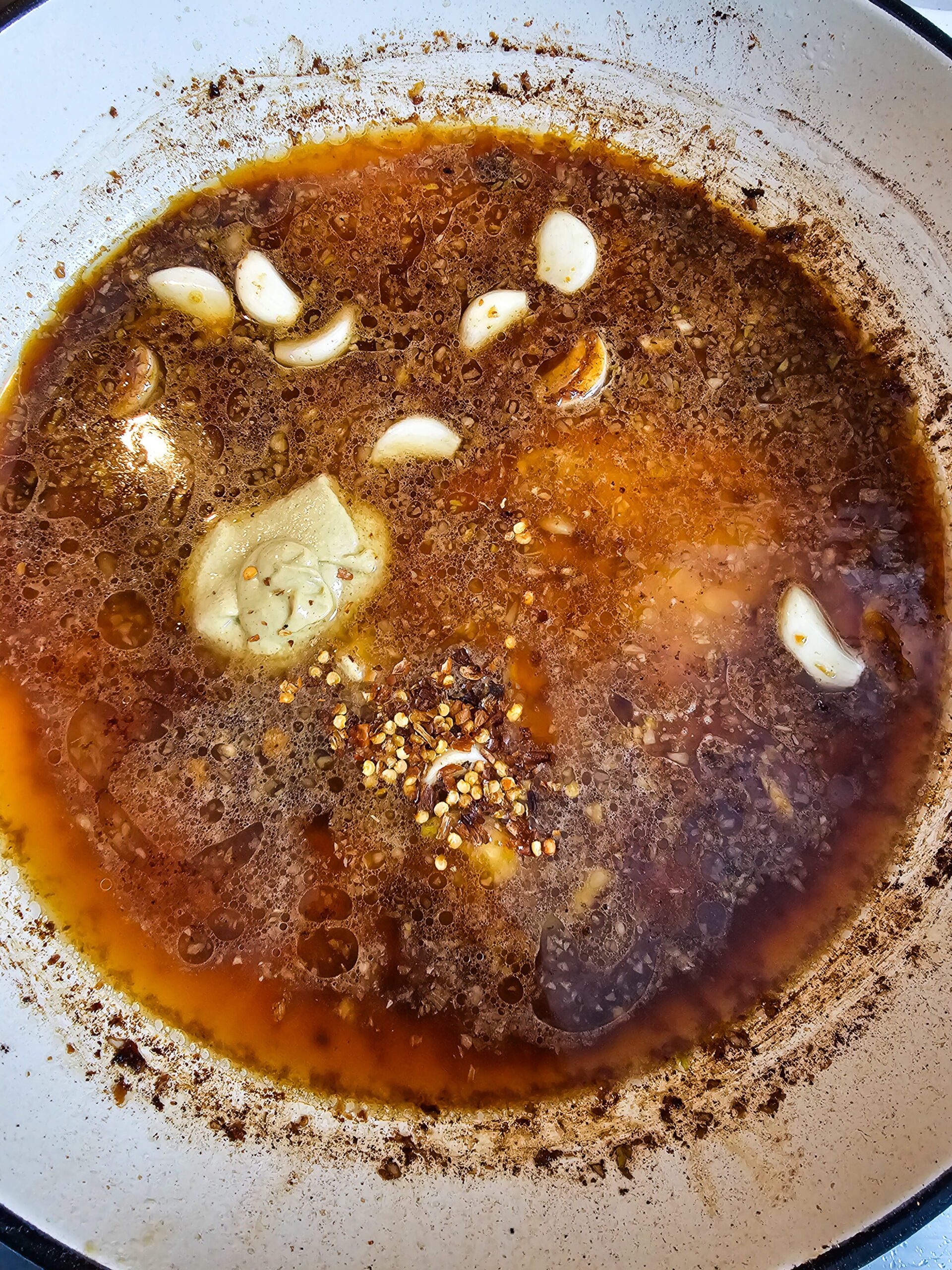 Whole garlic cloves caramelizing slowly in butter in a skillet turning golden and sweet for restaurant style creamy garlic chicken