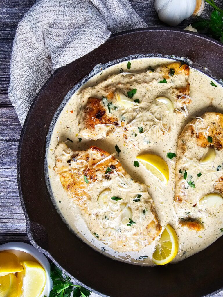 Restaurant style creamy garlic chicken cutlets on a serving platter showing golden seared crust and rich creamy garlic sauce