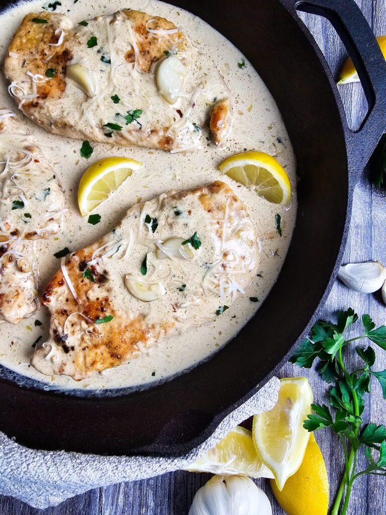 Restaurant style creamy garlic chicken skillet with caramelized whole garlic cloves in a rich cream sauce