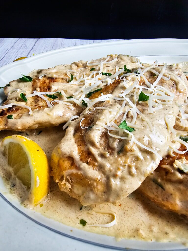 Restaurant style creamy garlic chicken skillet plated with mashed potatoes and roasted green beans