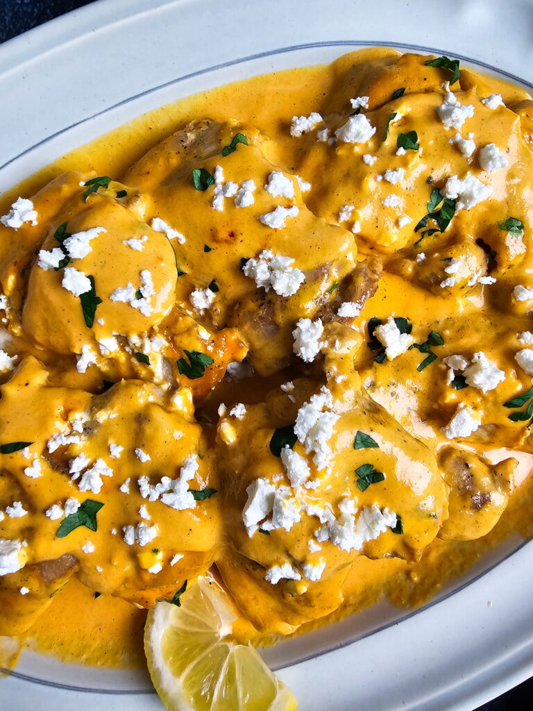 red pepper chicken thighs plated with fresh parsley garnish low carb dinner