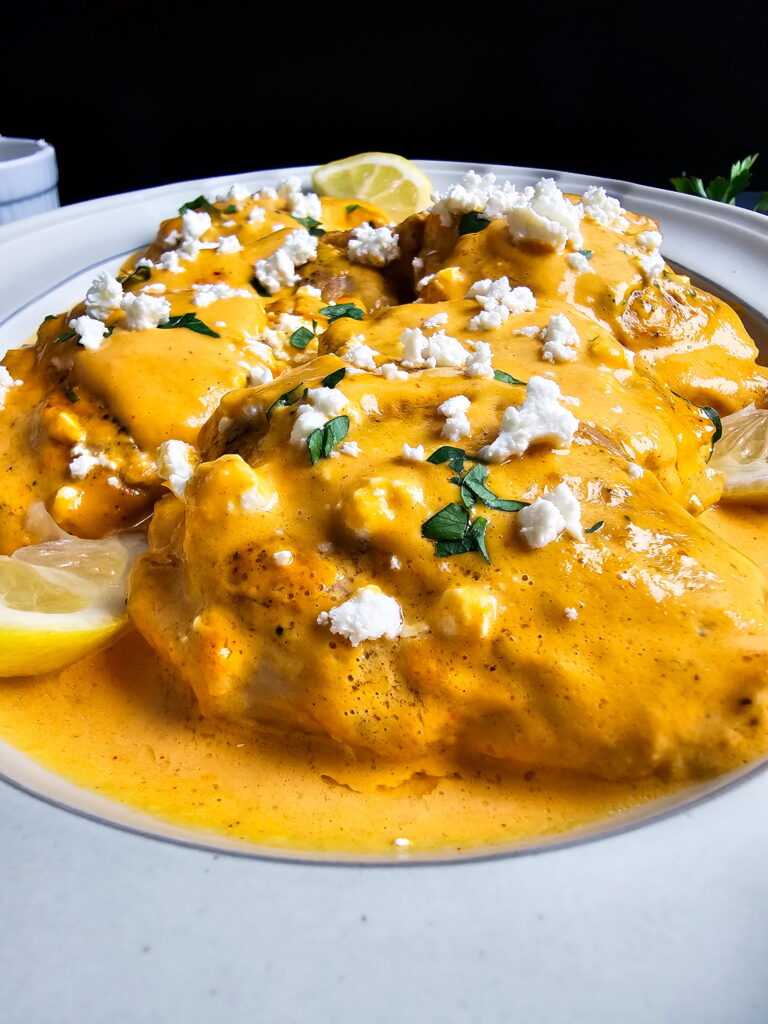 Low carb chicken thighs in roasted red pepper cream sauce with goat cheese in a skillet