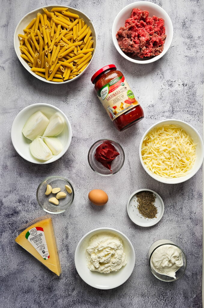 fresh ingredients for baked ziti with ricotta including ground beef cherry tomatoes and mozzarella