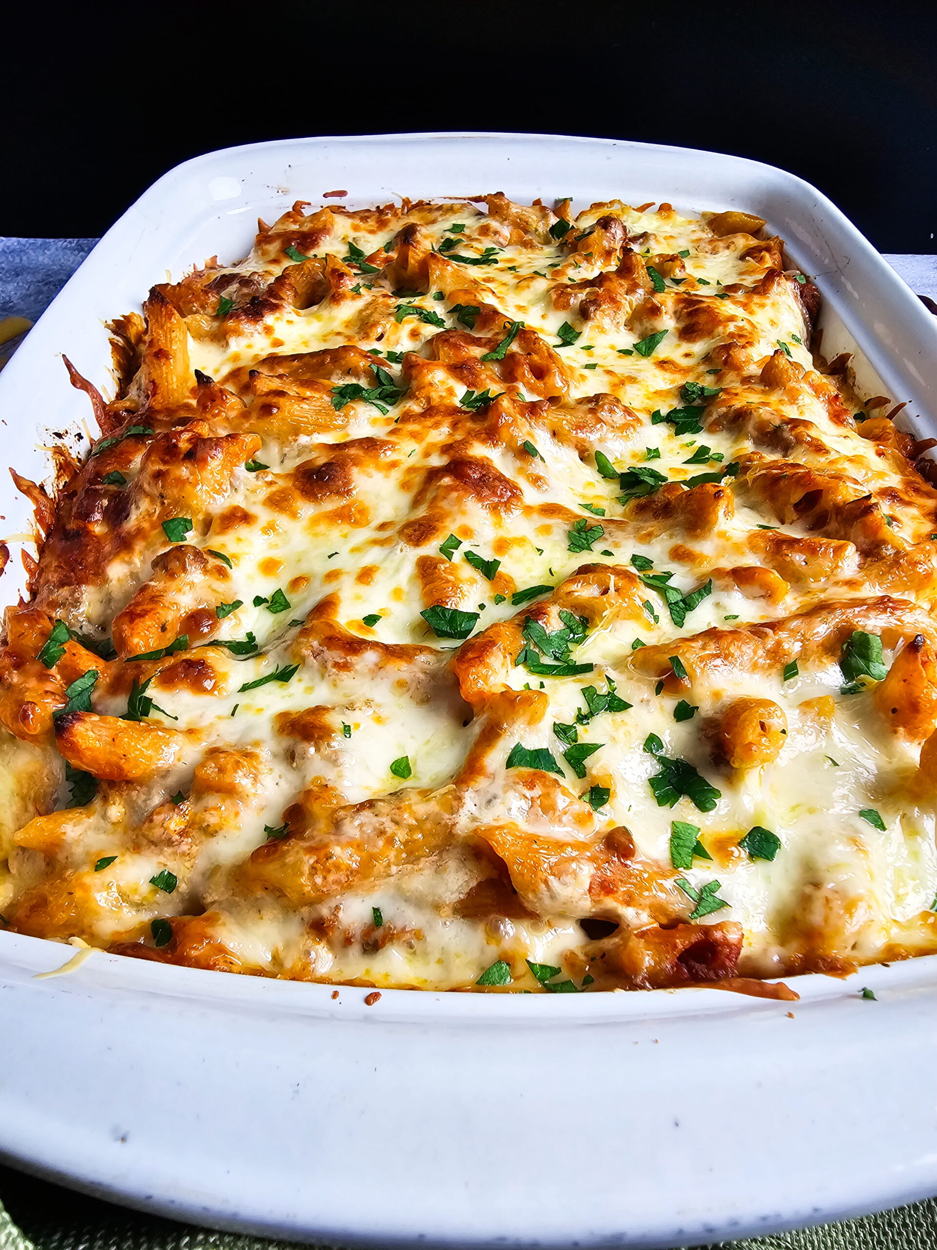 baked ziti with ricotta resting on the counter before slicing — shows clean layers holding together