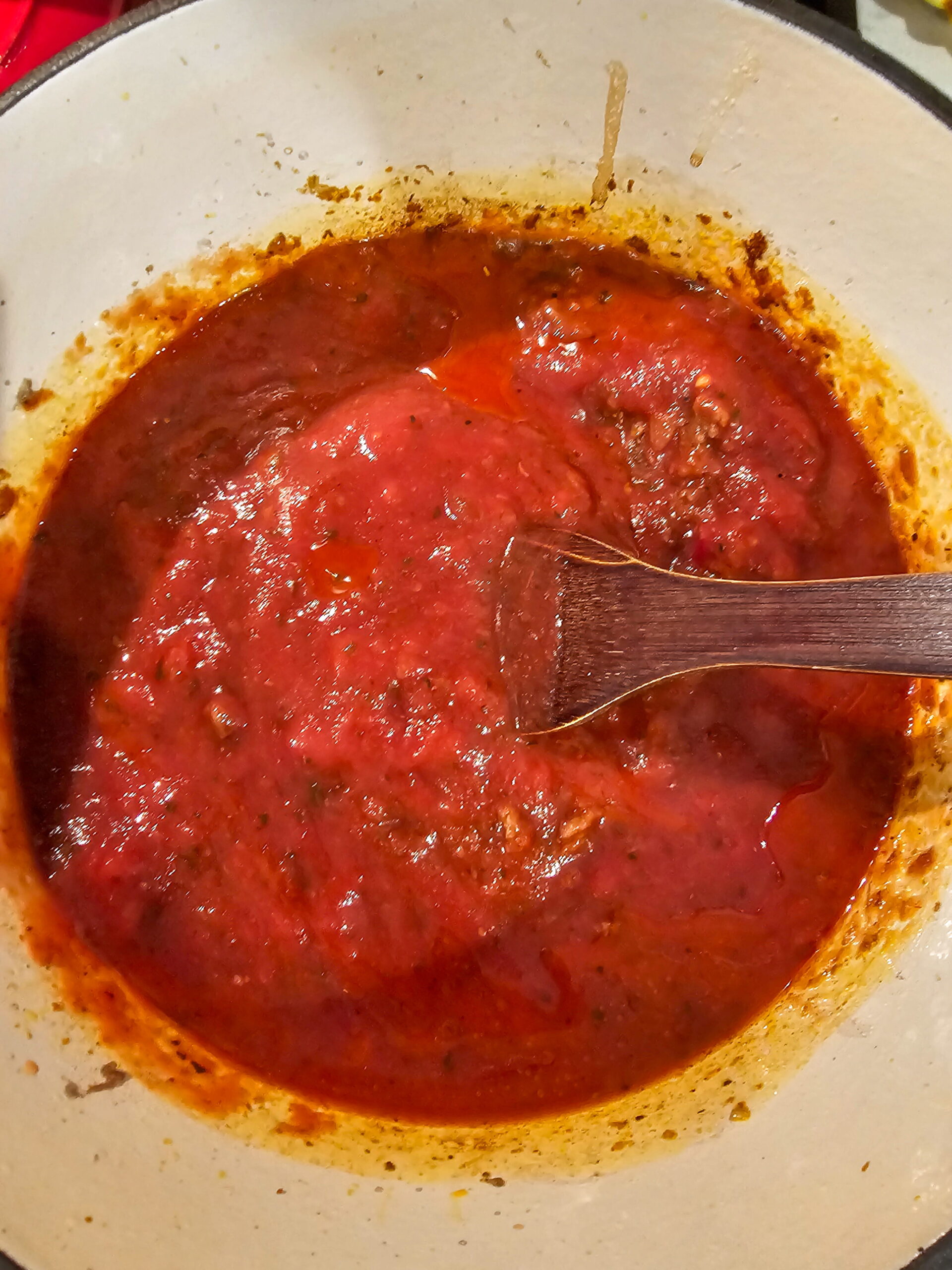 Tomato paste darkening to brick red in a skillet with browned ground beef