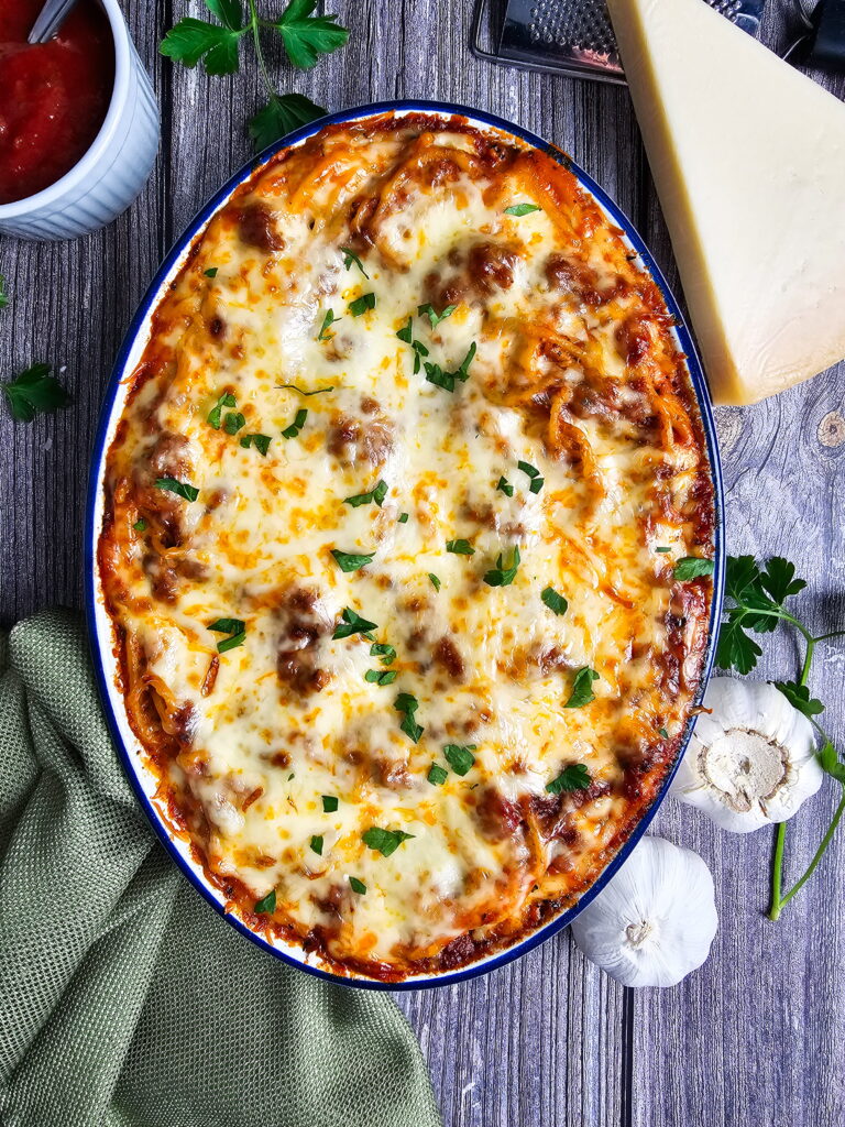 Baked spaghetti with Alfredo sauce in a 9x13 baking dish golden and bubbly