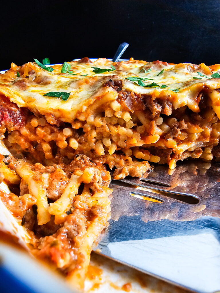 Baked spaghetti with Alfredo sauce portioned into airtight containers for meal prep and storage