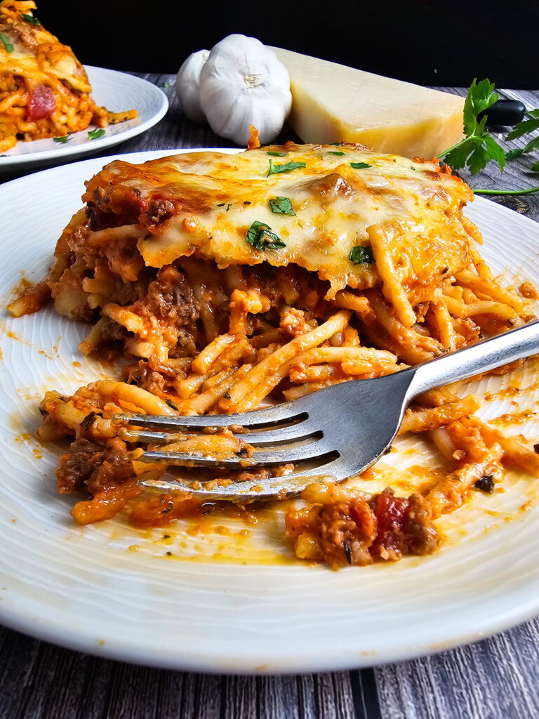 Spaghetti noodles being tossed with cream sauce in a large pot