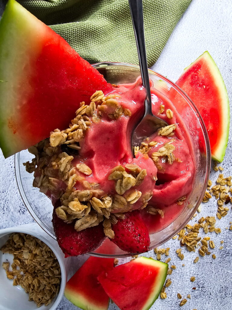 upclose photo watermelon smoothie with granola ready to serve with spoon
