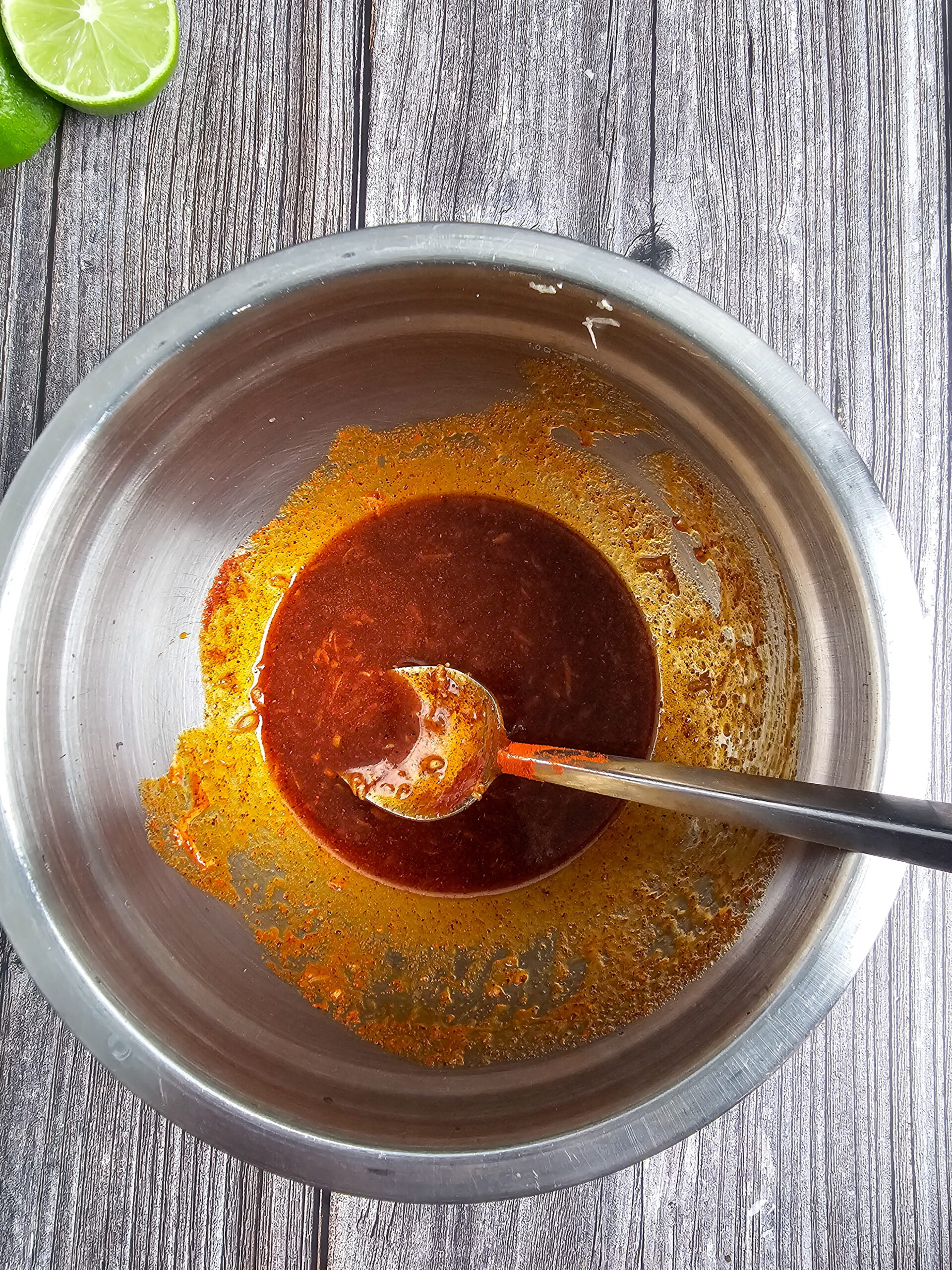 Chili lime marinade being whisked in a small bowl with honey, lime juice, smoked paprika, and melted butter