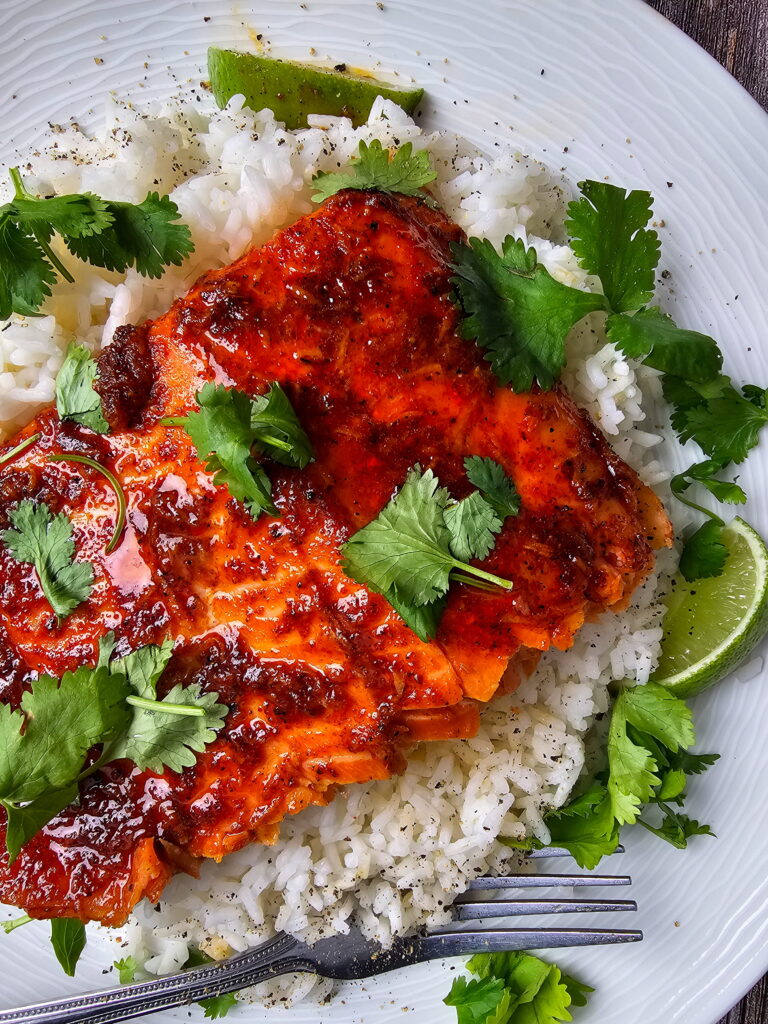 Chili lime trout fillet showing flaky moist interior with caramelized spice crust and lime wedges on the side